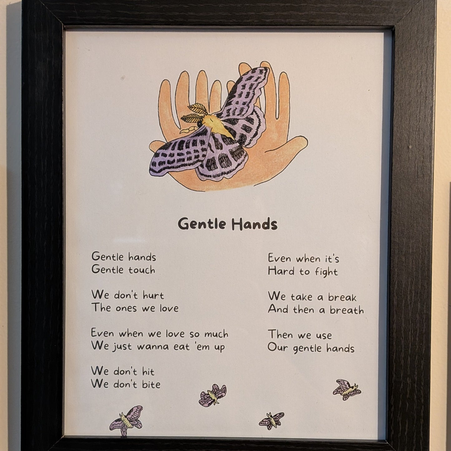 Framed artwork with illustration of hands and butterfly, accompanied by the song lyrics for "gentle hands."