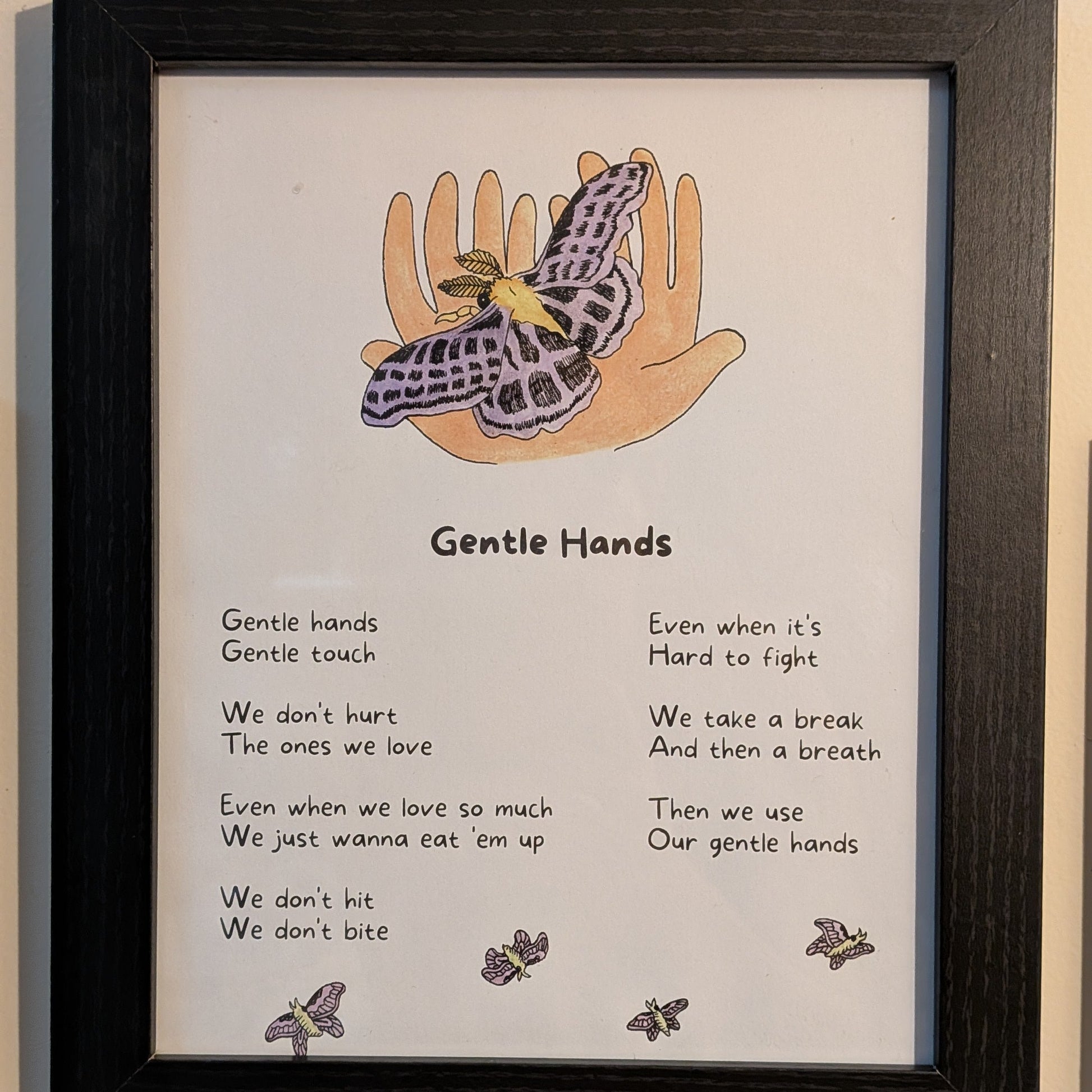 Framed artwork with illustration of hands and butterfly, accompanied by the song lyrics for "gentle hands."