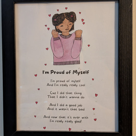 Framed artwork with a girl in a pink sweater and text on a white background with the lyrics to "i'm proud of myself."